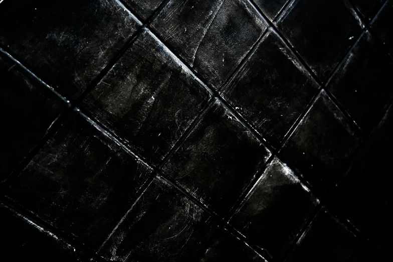 a white toilet sitting in a bathroom next to a black tiled wall, an album cover, inspired by Pierre Soulages, pexels contest winner, black metal album cover, diamond texture, handpaint texture, highly textured