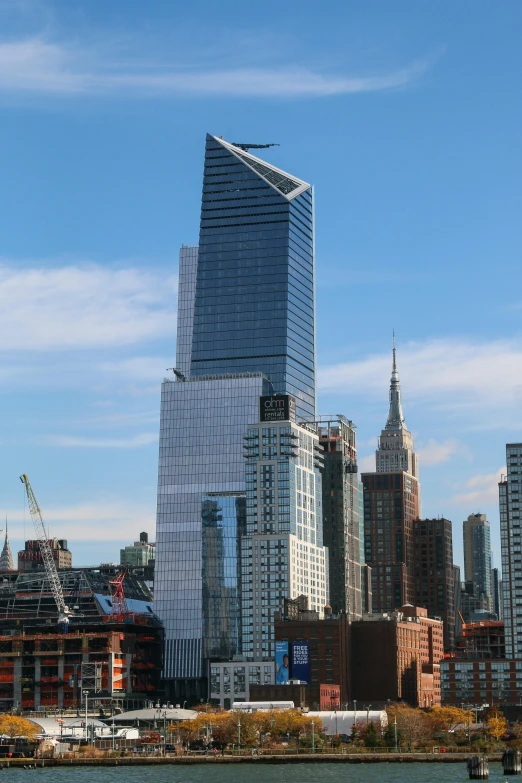 a large body of water with a city in the background, an album cover, perched on a skyscraper, during the day, bjarke ingels, viewed from afar