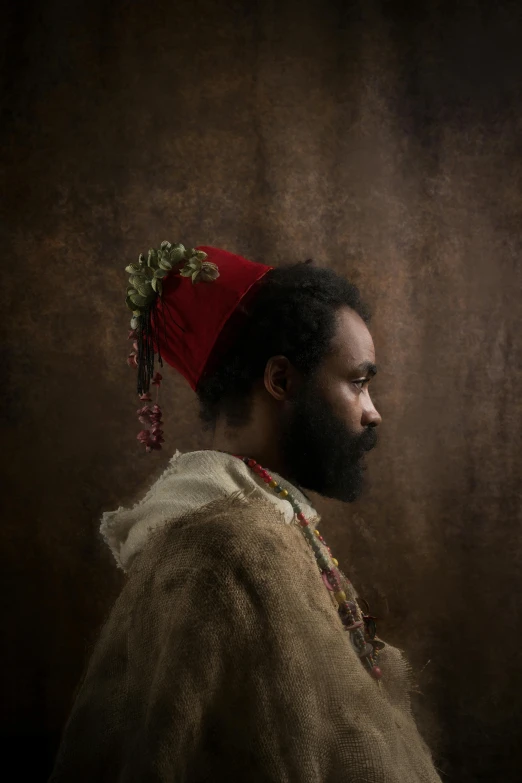 a man with a beard wearing a red hat, an album cover, inspired by Ras Akyem, pexels contest winner, renaissance, erwin olaf, somali attire, profile pose, flowers