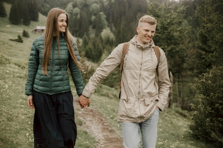 a man and a woman walking down a path, by Emma Andijewska, pexels contest winner, attractive girl, nordic folk, background image, holding each other