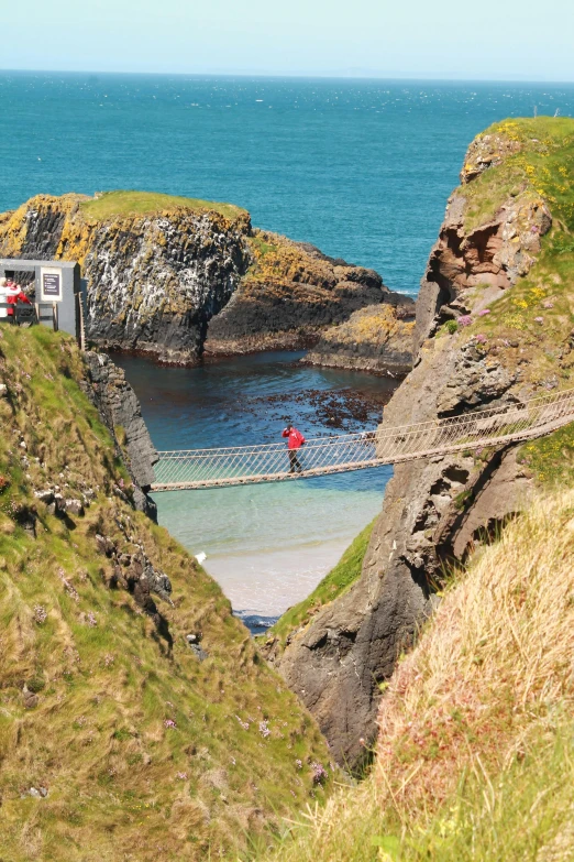 a group of people walking across a bridge over a body of water, coastal cliffs, rope bridge, carravaggion, beaches