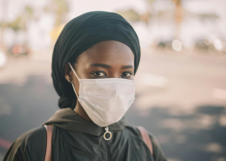 a close up of a person wearing a face mask, pexels contest winner, afrofuturism, muslim, healthcare worker, black girl, wearing a brown