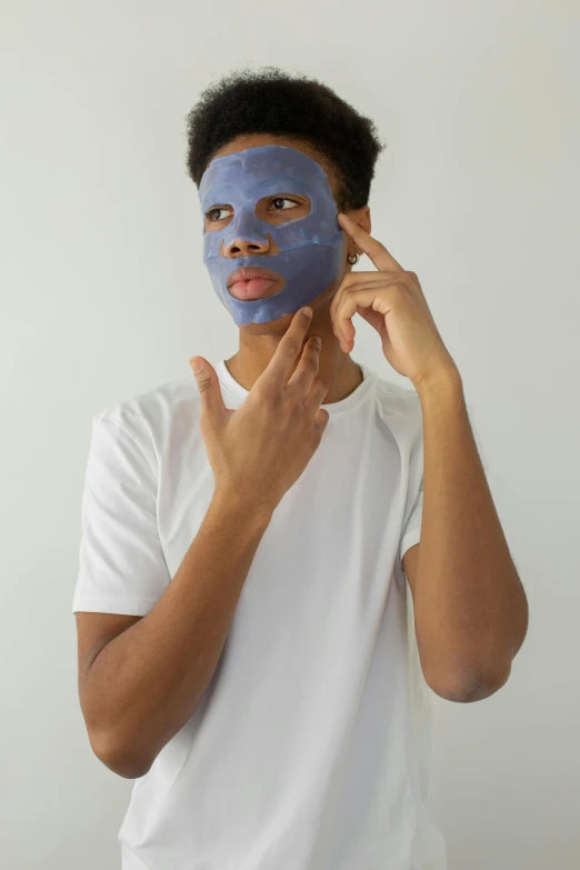 a man putting a blue face mask on his face, modeling, thumbnail, he is about 20 years old | short, ap