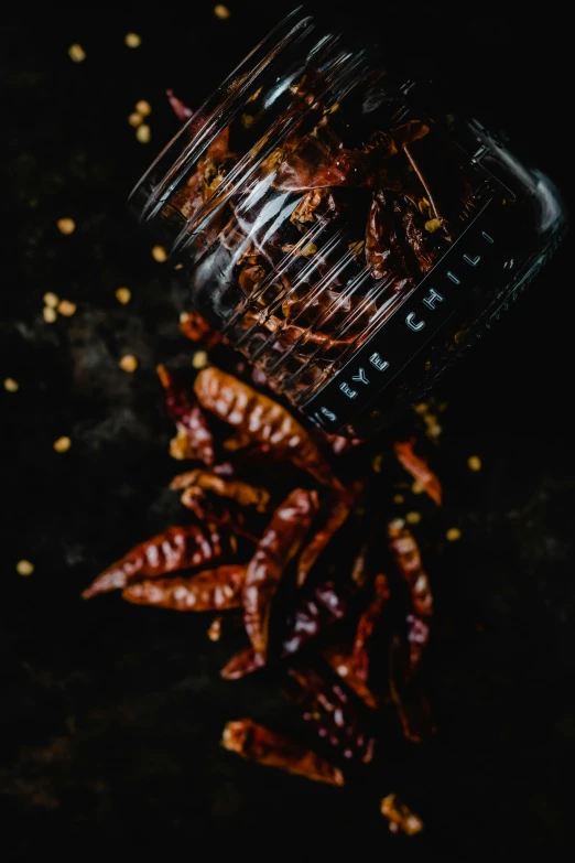 a jar of dried chili sitting on top of a table, pexels contest winner, process art, made of insects, splash image, full frame image, vine