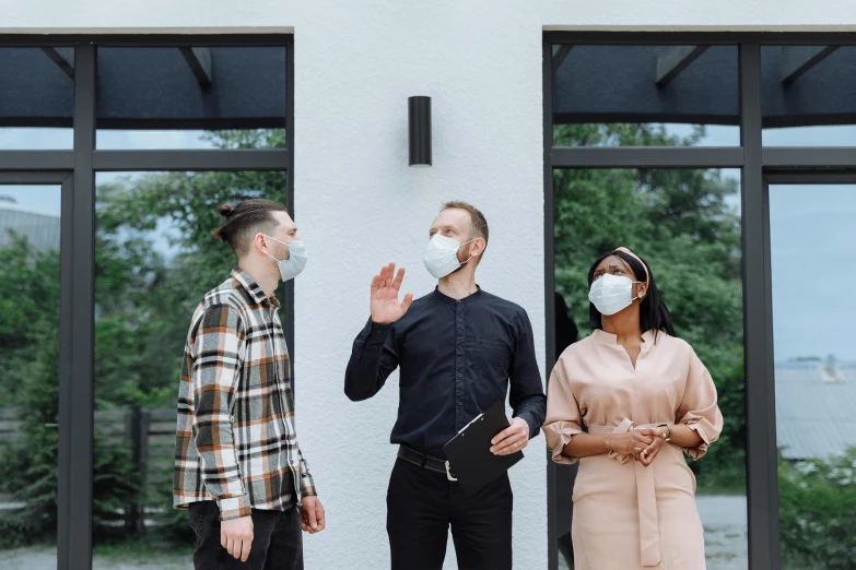 three people wearing face masks standing in front of a building, by Carey Morris, pexels contest winner, calmly conversing 8k, decoration, airbnb, medical mask