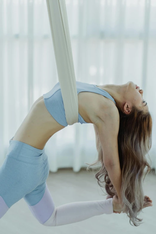 a woman doing aerial yoga on a hammock, an album cover, trending on pexels, arabesque, woman is curved, gif, low quality photo, bottom body close up