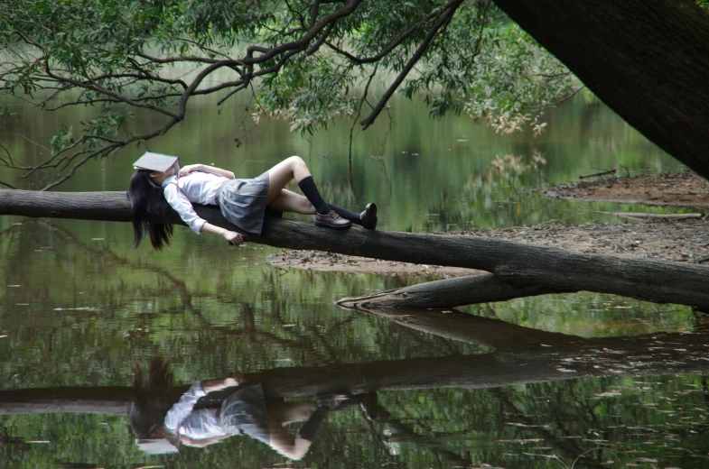 a person laying on a tree over a body of water, inspired by William Stott, conceptual art, realistic cosplay, sydney park, reading, reflect photograph