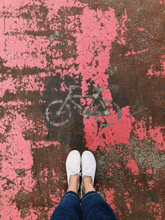 a person standing on a sidewalk with a bike painted on it, trending on unsplash, postminimalism, pink shoes, dull red flaking paint, snapchat photo, background image