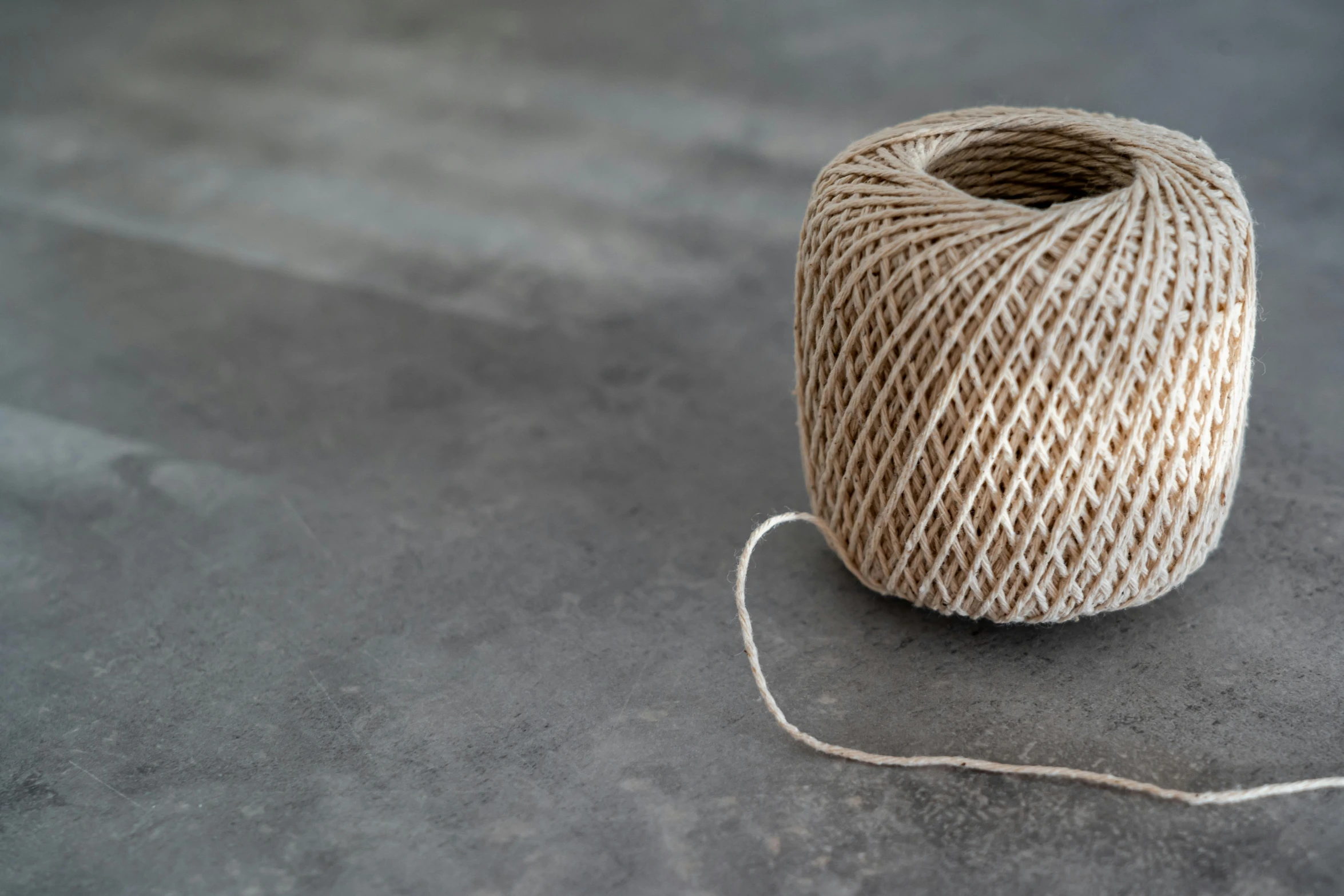 a spool of twine of twine on a table, inspired by Sarah Lucas, pexels contest winner, minimalism, taupe, geometrically realistic, ground - level medium shot, test