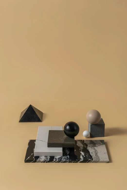 a couple of figurines sitting on top of a table, an abstract sculpture, inspired by Giorgio Morandi, kinetic art, flying black marble balls, triangle, matte photo, ignant