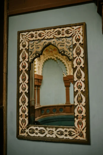 a close up of a mirror on a wall, a detailed painting, inspired by Riad Beyrouti, trending on unsplash, arts and crafts movement, wooden trim, square, mosque, arched back