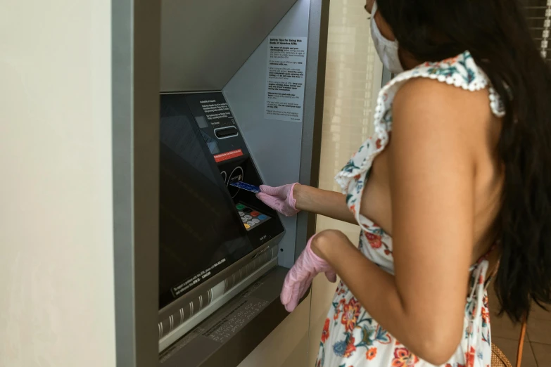 a woman in a floral dress using an atm machine, by Arabella Rankin, pexels contest winner, hyperrealism, wearing gloves, finely masked, cleaning future, a wooden