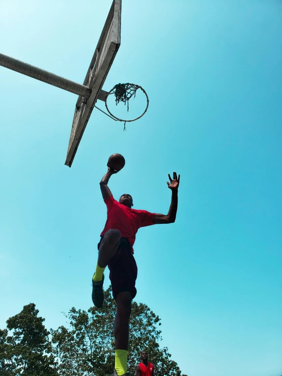 a man that is jumping in the air with a basketball, in the sun, profile image