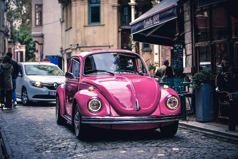 a pink vw beetle parked on a cobblestone street, by Adam Marczyński, pexels contest winner, renaissance, retro coloring, 🚿🗝📝