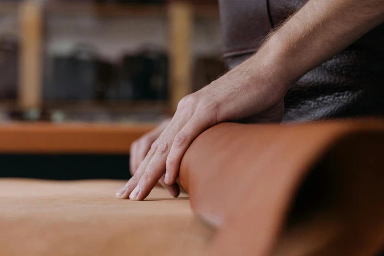 a close up of a person holding a piece of leather, arts and crafts movement, benches, thumbnail, large format, curved