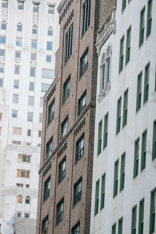 a traffic light hanging from the side of a tall building, a photo, by William Woodward, trending on unsplash, white houses, brick building, background image