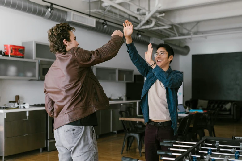 two men giving each other a high five, pexels contest winner, in a open-space working space, avatar image, asian man, lachlan bailey