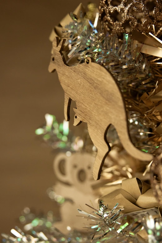 a close up of a christmas tree with decorations, a surrealist sculpture, by Fiona Stephenson, kinetic art, “ golden cup, kangaroo, laser cut, with detailed wood
