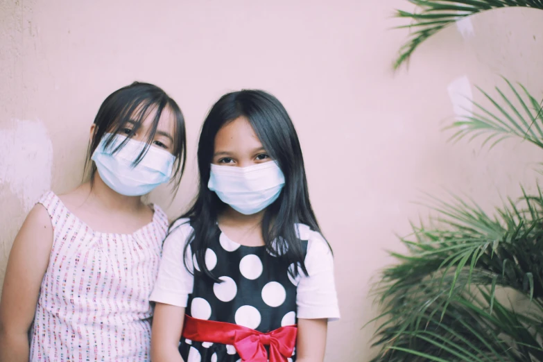 a couple of young girls standing next to each other, pexels contest winner, masked doctors, nivanh chanthara, haze, for kids