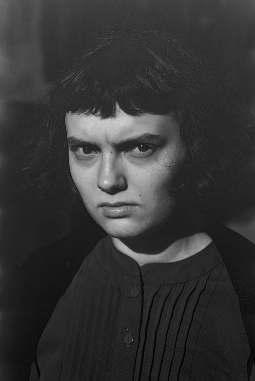 a black and white photo of a woman, by Gyula Basch, angry frown, square face, french bob, dreamlike stanley kubrick