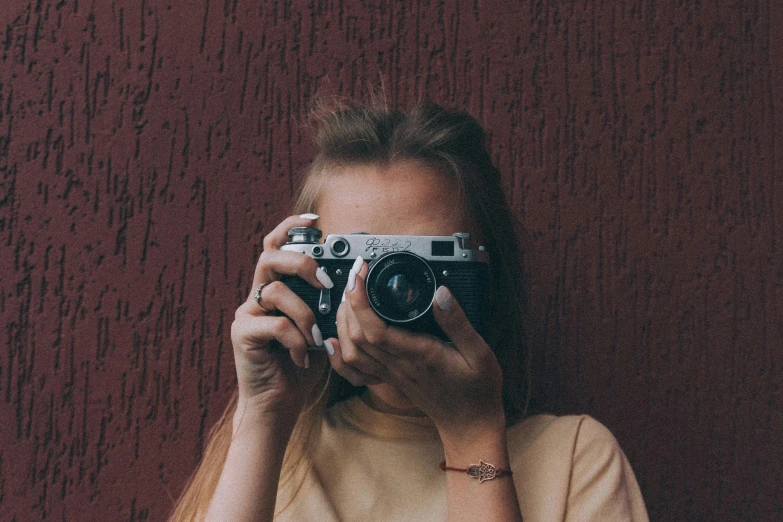 a woman taking a picture with a camera, a picture, inspired by Elsa Bleda, unsplash contest winner, photorealism, lovingly looking at camera, in retro colors, simple aesthetic, pixvy