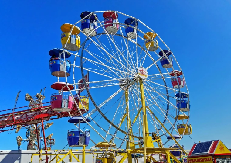 a ferris wheel at a carnival with a blue sky in the background, by Douglas Shuler, pexels contest winner, pop art, some yellow and blue, 15081959 21121991 01012000 4k, wyoming, various colors