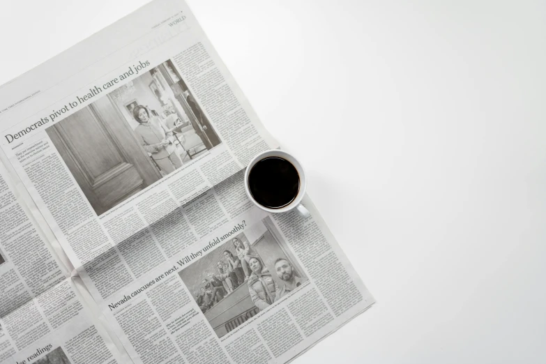 a cup of coffee sitting on top of a newspaper, by Matthias Stom, unsplash contest winner, photorealism, black on white paper, cinestill hasselblad 8 5 mm, magdalena radziej, wide high angle view