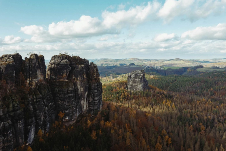 a large rock formation in the middle of a forest, by Adam Marczyński, pexels contest winner, art nouveau, 4 k cinematic panoramic view, sharp cliffs, high angle shot, majestic spires