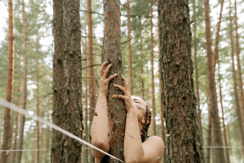 a naked woman leaning against a tree in a forest, unsplash, land art, ((trees))