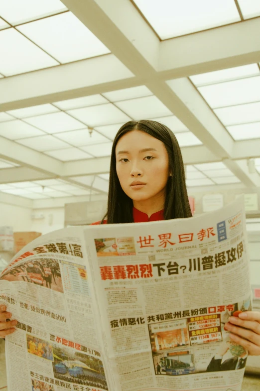 a woman reading a newspaper in an office, by Fei Danxu, sci - fi film still, young asian girl, red magic surrounds her, looking straight ahead