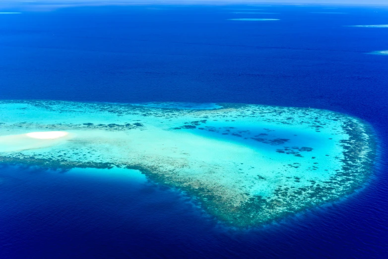 a small island in the middle of the ocean, by Peter Churcher, pexels contest winner, hurufiyya, reefs, white and blue, alternate angle, fan favorite