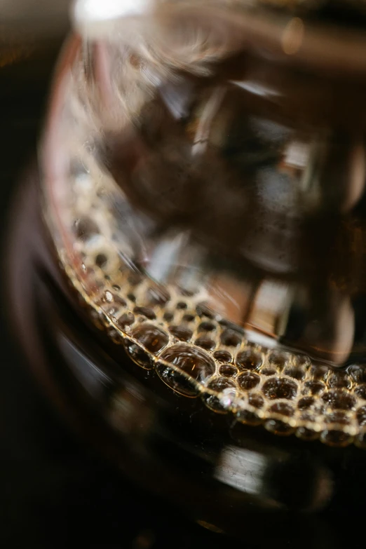 a glass filled with liquid sitting on top of a table, a macro photograph, by Andrew Domachowski, trypophobia, cold brew coffee ), intricate details. front on, snakeskin