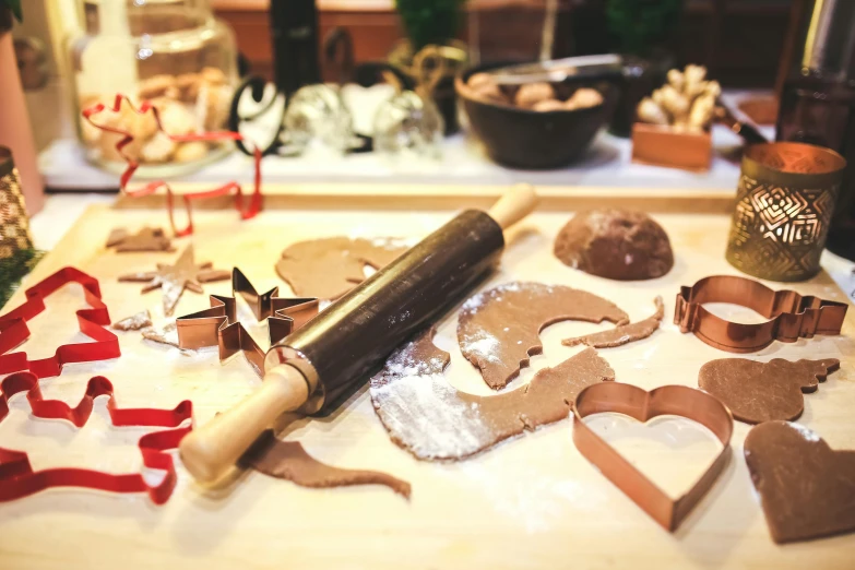 a rolling pin sitting on top of a wooden table, by Julia Pishtar, pexels contest winner, festive atmosphere, baking cookies, “ iron bark, various posed