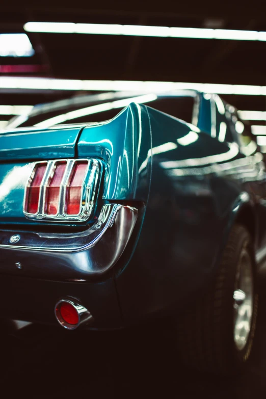 a blue car parked in a parking garage, a colorized photo, pexels contest winner, photorealism, tail lights, mustang, medium closeup, tiny details