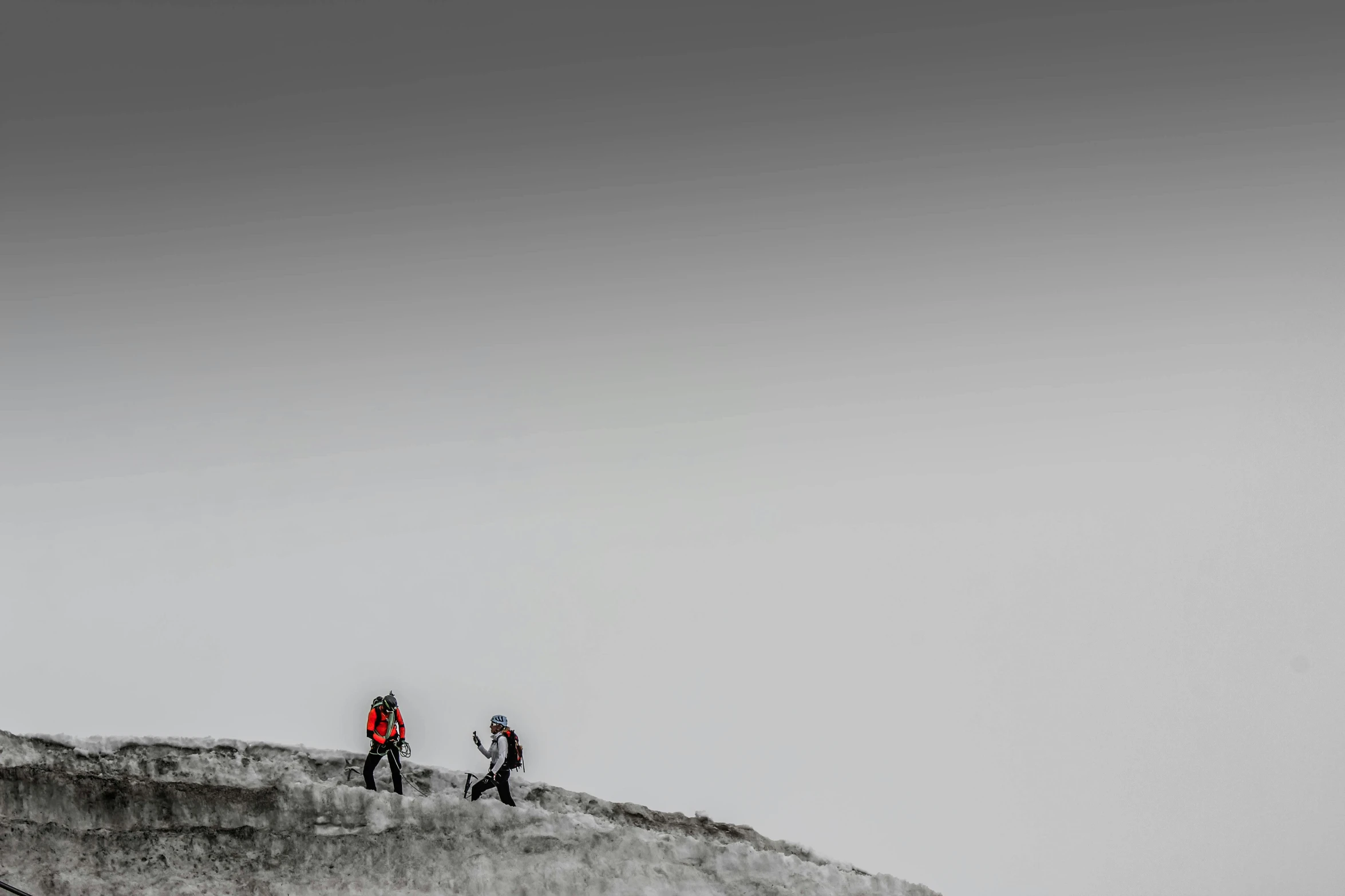 a couple of people standing on top of a snow covered slope, a picture, by Adam Marczyński, minimalism, rock climbers climbing a rock, black and white and red colors, blurred, people at work