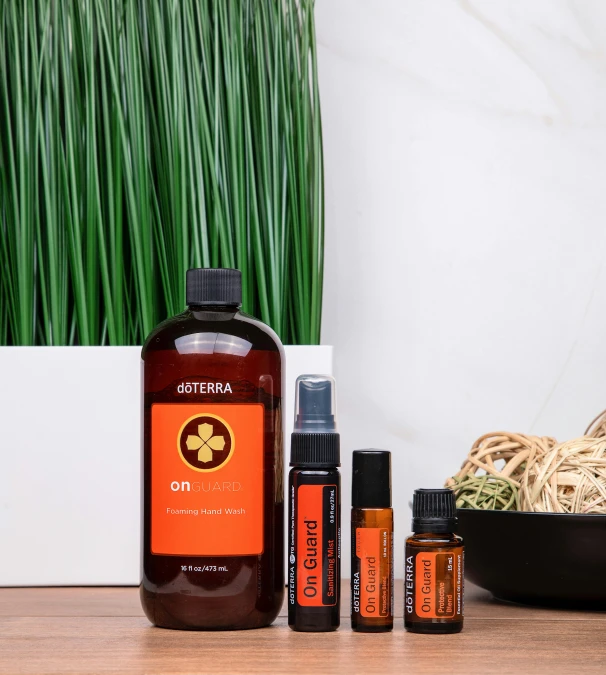 a wooden table topped with bottles of essential oils, a portrait, by Julia Pishtar, unsplash, orange and black tones, focus on full - body, detailed product image, orange grass