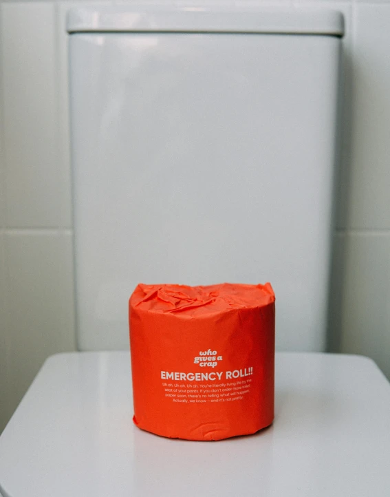 an orange emergency blanket sitting on top of a toilet, by Jessie Algie, unsplash, made of lab tissue, packaging, large crown, melbourne