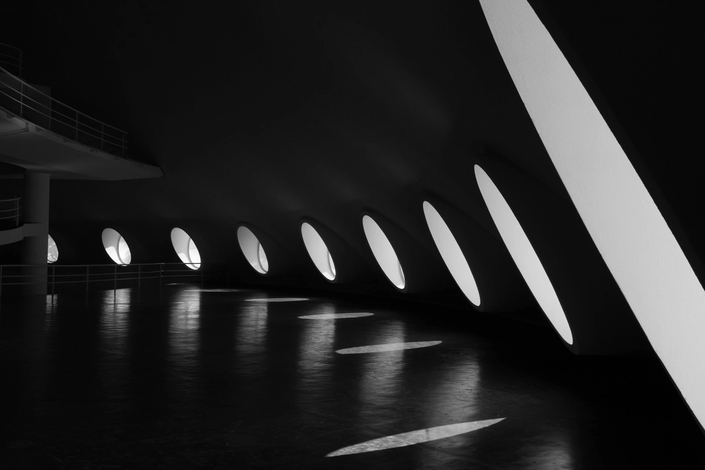 a black and white photo of the inside of a building, inspired by Zha Shibiao, unsplash contest winner, light and space, lamps on ground, smooth round shapes, flourescent spot lights, beautiful futuristic new delhi