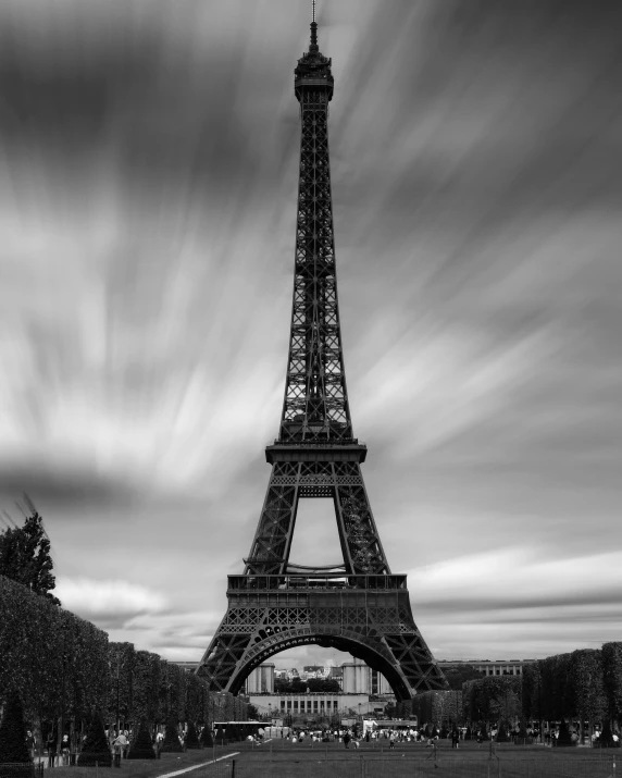 a black and white photo of the eiffel tower, a black and white photo, by Daniel Gelon, dramatic skies, motion blur, a quaint, arc