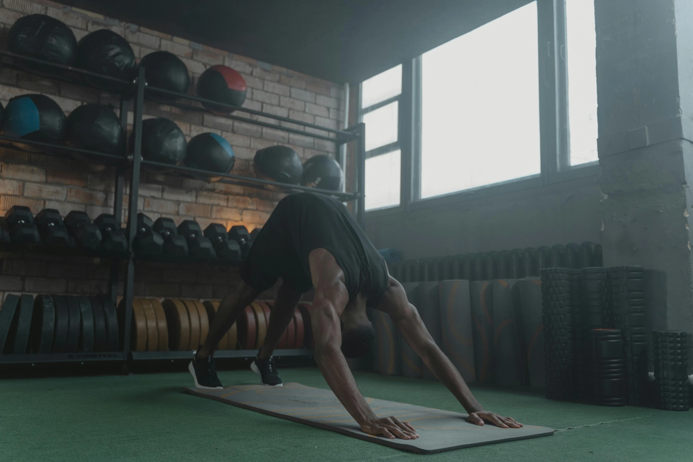 a man doing a handstand on a mat in a gym, pexels contest winner, hurufiyya, 8k vfx render, background image, lachlan bailey, dark taint :: athletic