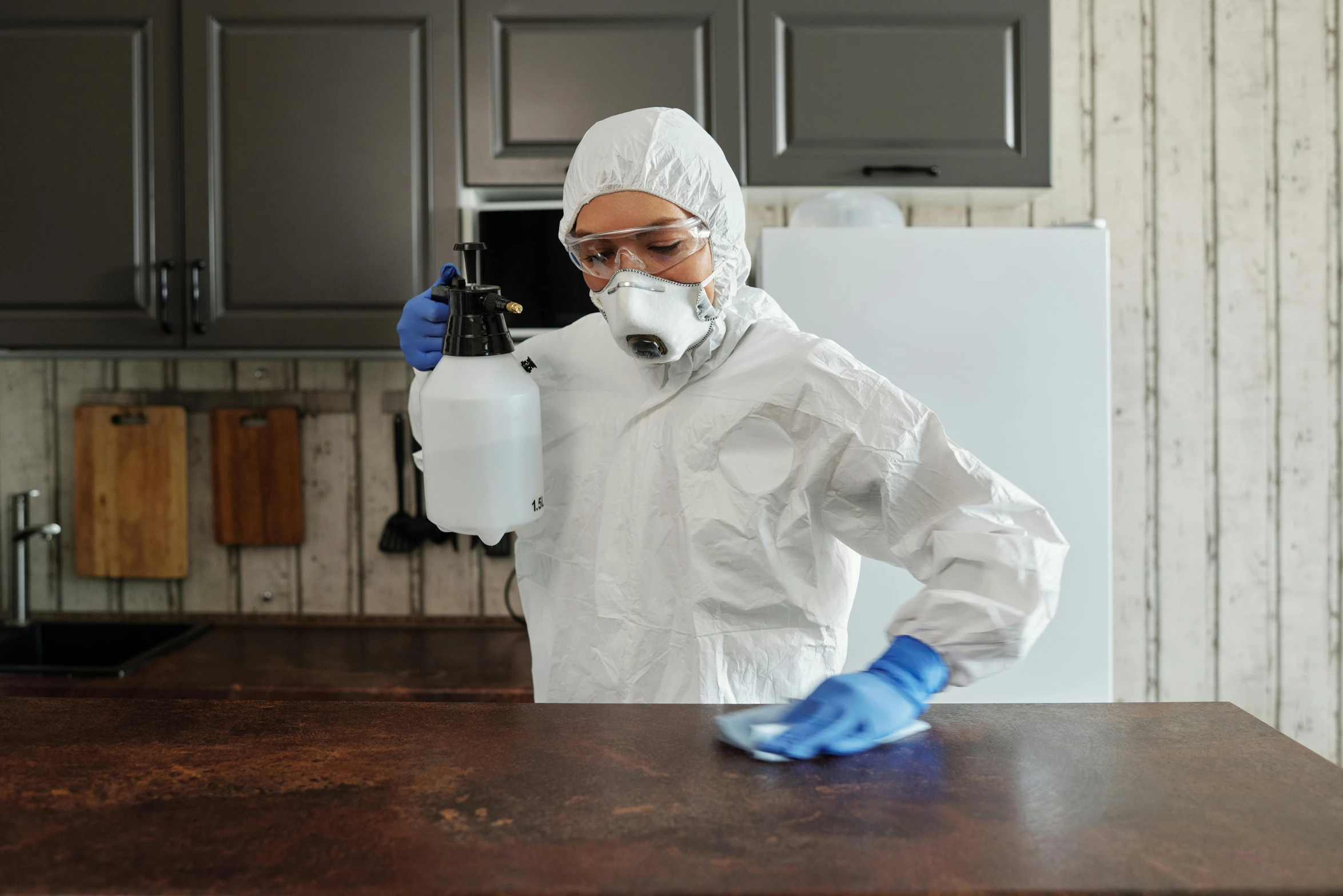 a woman in protective gear cleaning a kitchen counter, pexels contest winner, hyperrealism, avatar image, on a wooden table, full body image, man