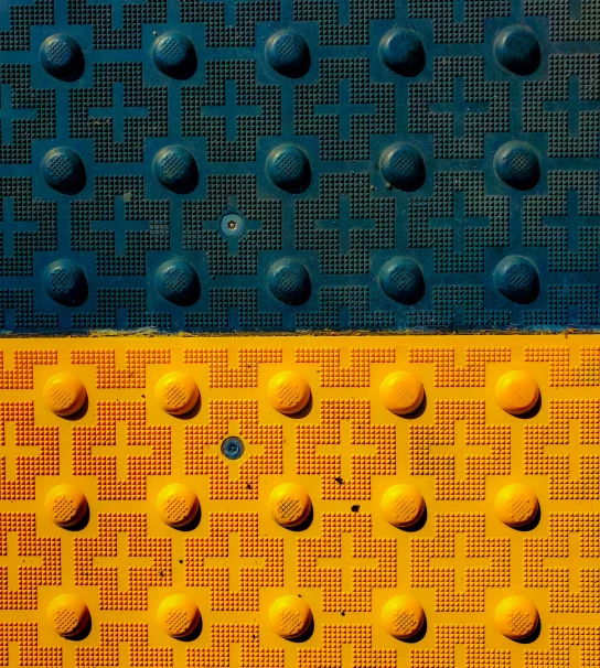 a close up of a yellow and blue background, inspired by Ernst, unsplash, sewer background, studs, two colors, andrey gordeev