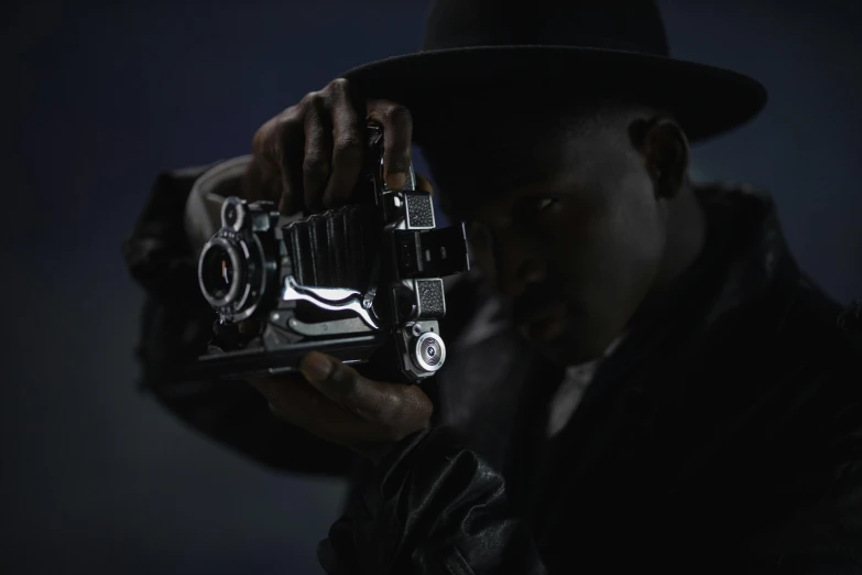 a man holding a camera up to his face, inspired by Gordon Parks, photorealism, black cowboy, film noir lighting, colour photograph, hasselblad photograph