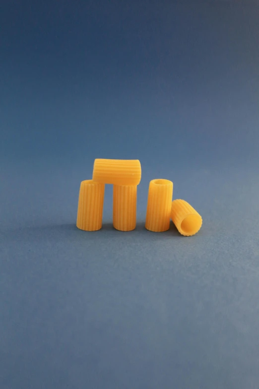 a pair of yellow ear plugs sitting on top of a blue surface, by Ryan Pancoast, plasticien, arms made out of spaghetti, tall columns, thumbnail, 3 - piece