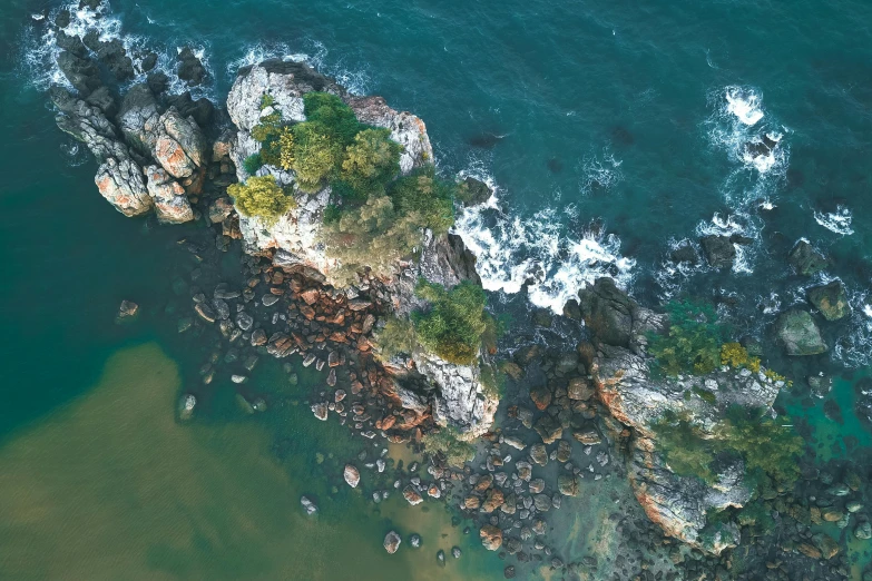 a group of rocks sitting on top of a body of water, pexels contest winner, helicopter view, manly, lush nature, beautiful composition 3 - d 4 k