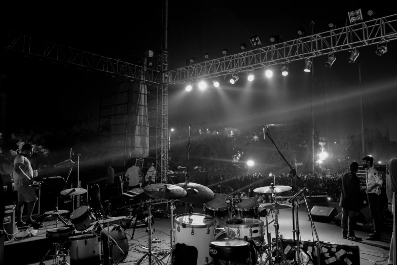 a group of people standing on top of a stage, drumkit, grayscale photography, bangalore, foggy lights