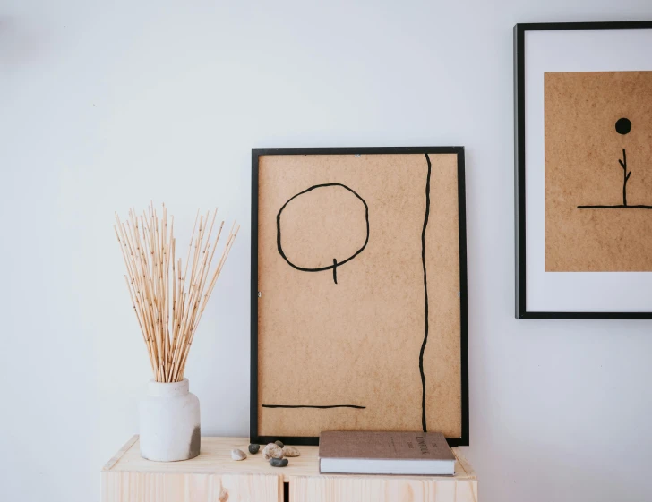 a white vase sitting on top of a wooden table, a minimalist painting, trending on pexels, single line drawing, abstract people in frame, wooden decoration, brown stubble