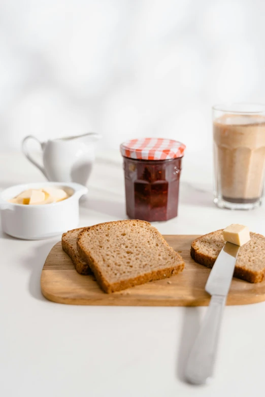 a wooden cutting board topped with slices of bread, jar of honey, product image, unbeatable quality, morning coffee