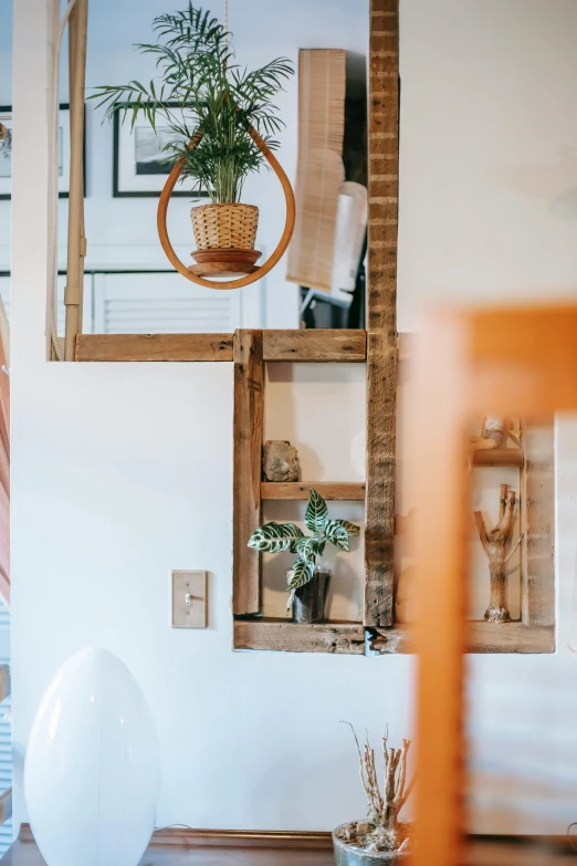 a white vase sitting on top of a wooden table, a picture, between two chairs over a toilet, in a white boho style studio, zoomed in, things hanging from ceiling