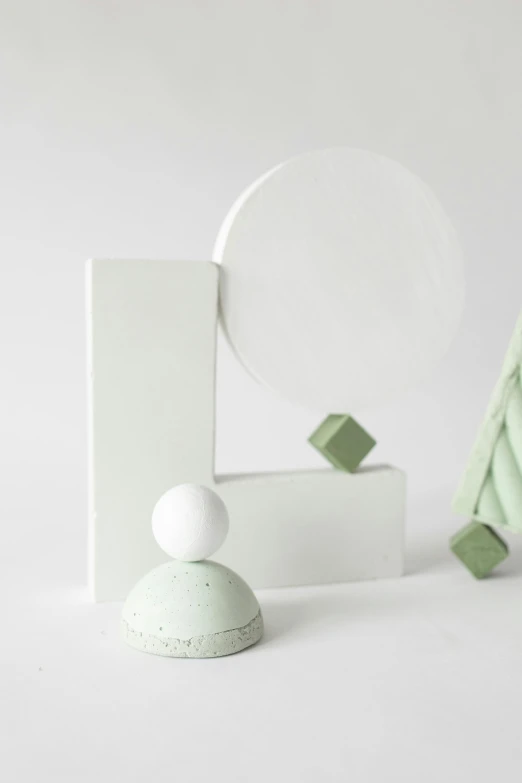 a group of objects sitting on top of a white surface, an abstract sculpture, inspired by Art Green, nordic pastel colors, with a mirror, singularity sculpted �ー etsy, small stature